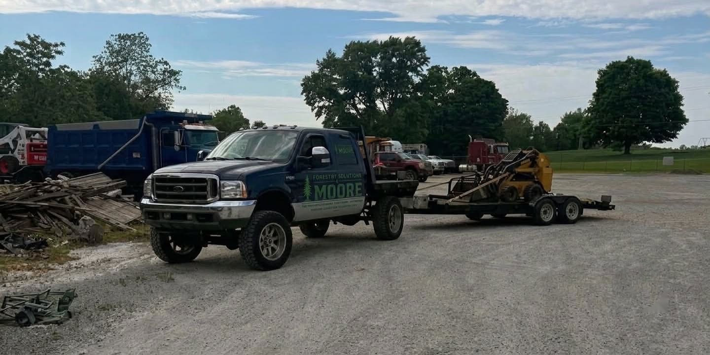 Forestry Solutions & Moore truck with trailer and skid steer